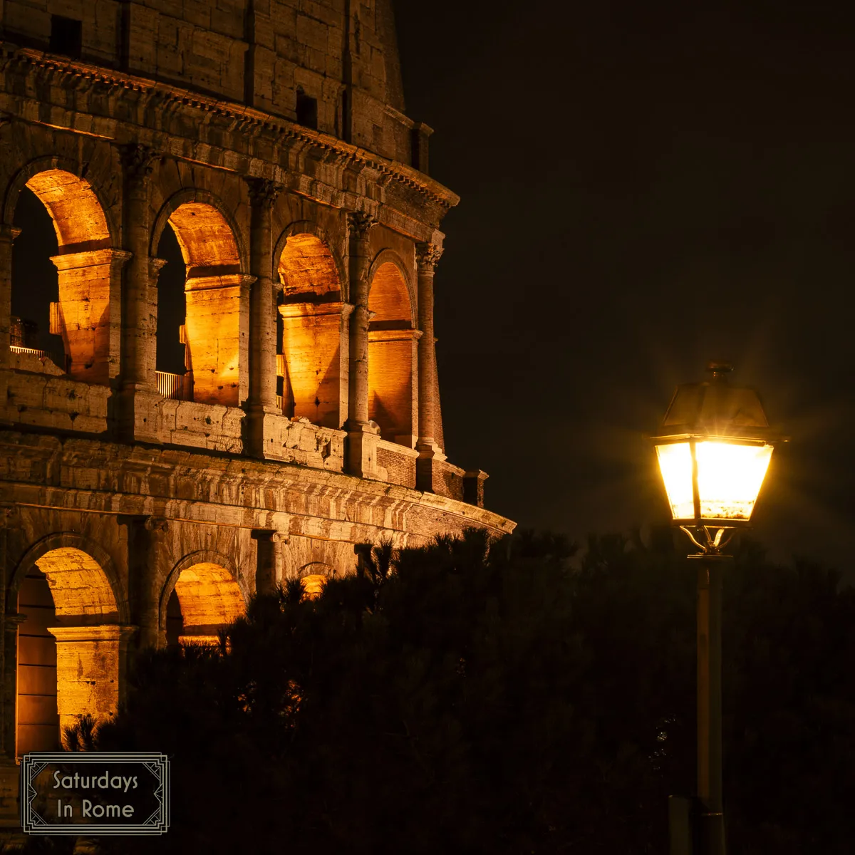 A night view of the Colosseum with a nearby streetlight